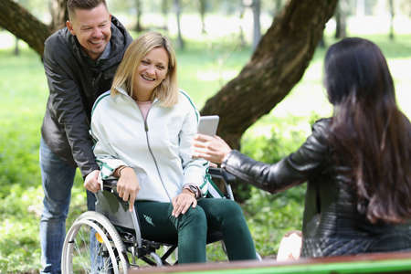 Disabled woman spending leisure time with friends in parkの写真素材
