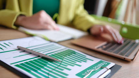 Accountant working with financial report and typing on modern laptopの写真素材