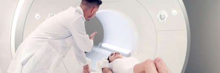 Medical laboratory doctor radiologist controls MRI CT scan patient undergoing procedureの写真素材