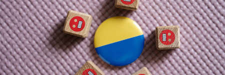 Badge with flag of Ukraine lying among evil emoticons closeupの写真素材