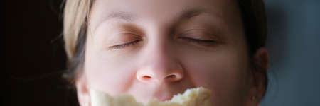Woman sniffing delicious fragrant piece of white breadの写真素材