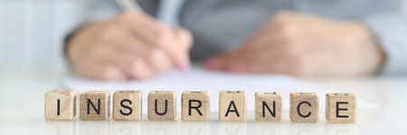 Insurance agent fills out insurance form in office closeupの写真素材