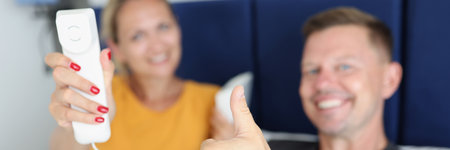Married couple is holding handset and phone and thumbs up gesture in hotel roomの写真素材