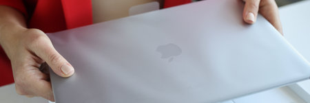 Woman holds an Apple Macbook Pro laptop in packageのeditorial素材