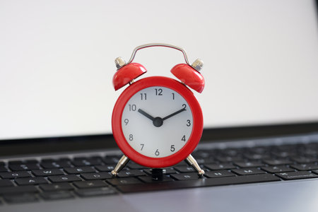 Red alarm clock for ten on laptop keyboard for business termsの写真素材