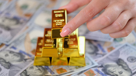 Woman hand puts golden ingot of dollar banknote