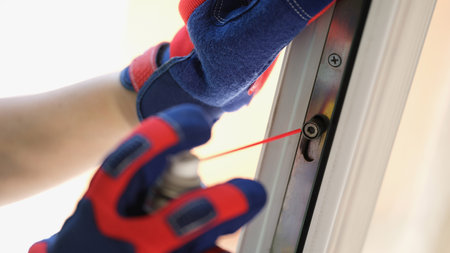 Man using lubricate in spray can for lock of windowの写真素材