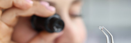 Jeweller examine polished diamond through magnifying glass, diamond jewellery under grading