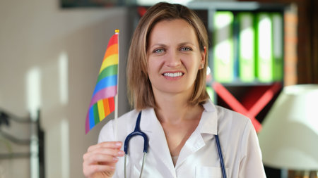Smiling female doctor with lgbt flag in her hand in clinic office.の写真素材