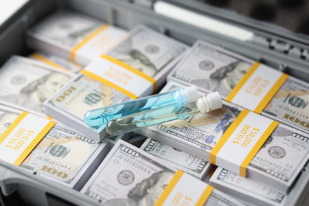 Chemical drug in a flask on money in a suitcase, close-upの写真素材