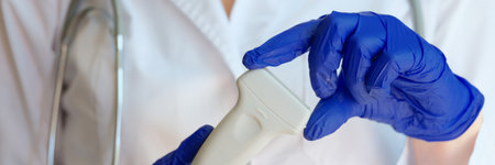 Doctor holding ultrasound scanner in clinic closeup