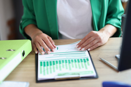 Woman working with statistics documents in officeの写真素材