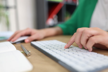 Woman hand using computer mouse and typing on keyboardの写真素材