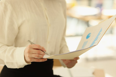 Business woman takes notes in financial report close-up.の写真素材