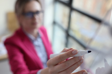 Female manager drawing on board with marker, selected focus.の写真素材