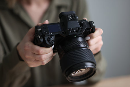 Professional photographer holds camera with big lens