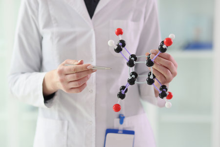 Lab assistant demonstrates molecule model close viewの写真素材