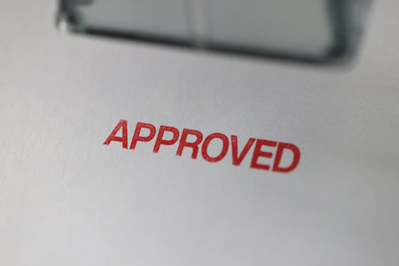Red word Approved stamped on papers close upper viewの写真素材