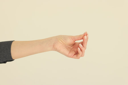Hand of woman putting fingers together shows asking moneyの写真素材