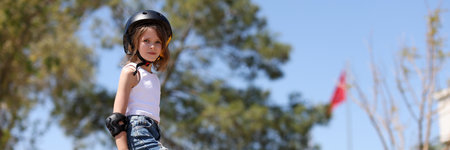 Child girl playing skateboarding in parking lot