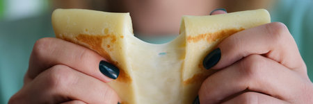Person holds flour pancake with cheese filling closeupの写真素材