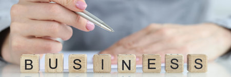 Word business and a businessman is holding pen and documentの写真素材