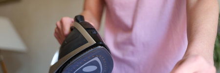Woman ironing bed linen on special board using steam ironの写真素材