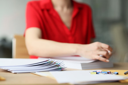 Female office worker in red blouse looks for documents