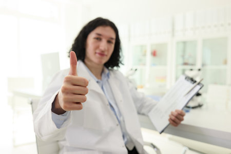 Satisfied male laboratory worker shows thumb up gestureの写真素材