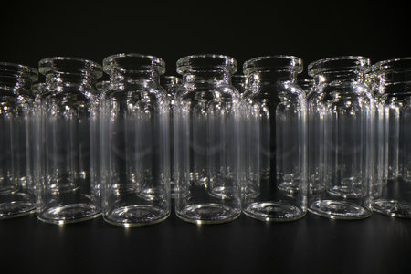 Empty vials for vaccines stand in row on dark background