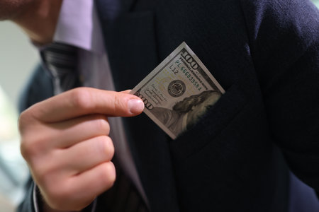 Successful businessman takes dollar banknote out of pocket