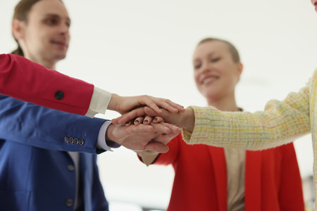 Cheerful colleagues make unity gesture to show support