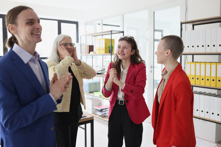 Cheerful colleagues smile and laugh discussing situationsの写真素材