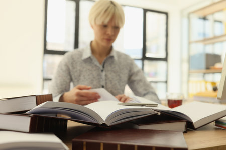 Female employee reads books to find information for researchの写真素材