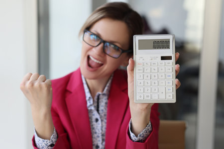 Excited business woman in the office showing one million number on calculatorの写真素材
