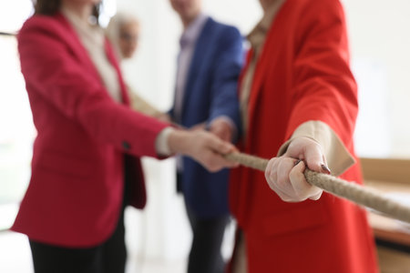 Business team plays tag war at corporate training in officeの写真素材