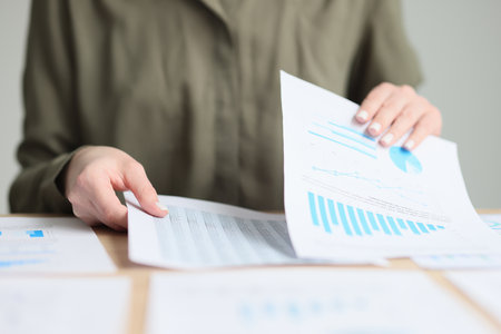 Manager checkups papers with business statistics in officeの写真素材