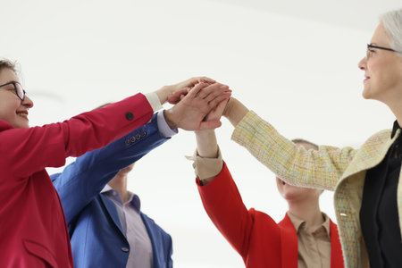 Happy businesspeople join hands during teambuilding trainingの写真素材