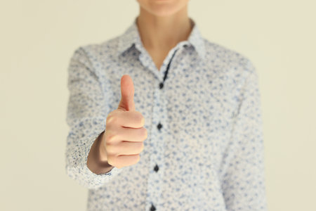 Female person shows thumb up gesture expressing approvalの写真素材