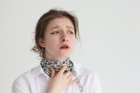 Young female holds on to chained neck feeling pain in throat