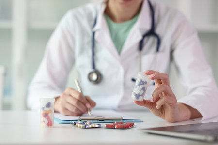 Doctor prescribes medicine sitting at table in clinicの写真素材