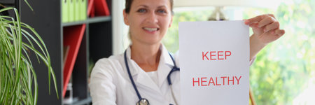 Smiling female doctor is holding inscription keep healthyの写真素材