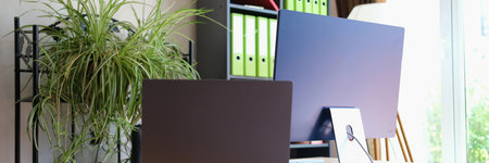 Comfortable office interior with modern laptop and pcの写真素材