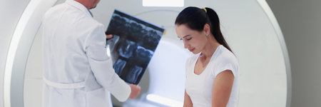 Practitioner looking at mri picture, female patient at medical consultationの写真素材