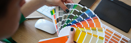 Female designer holding color samples and choosing color samples for projects.の写真素材