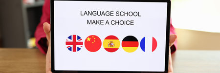 Woman holds tablet with text language school and offers to choose foreign language to study.の写真素材