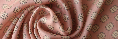 Swirled pink fabric with geometric ornament.