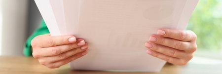 Manager reads documents while sitting at office desk.