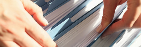 Female hands sort through documents in a folder, close-up