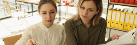 An employee in office teaches a woman computer literacyの写真素材